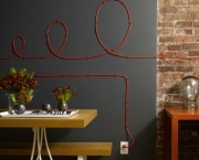 Season 5 Design Star competitor Moeller design in this office dining room area with red wiring in decorative design on gray wall, table with tray and flowers, and brick wall behind table with head decor.