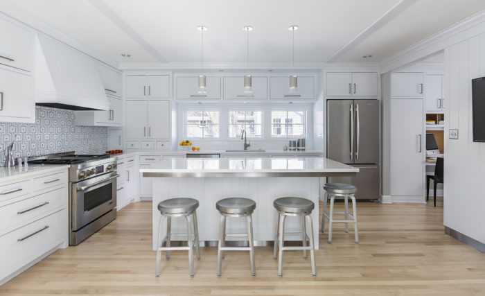 White kitchen with island and stainless steel appliances